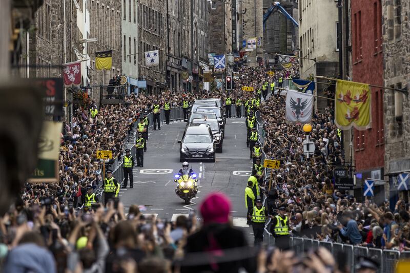 Members of the public gather on the Royal Mile in Edinburgh to watch the hearse carrying the coffin of Queen Elizabeth to the Palace of Holyroodhouse. PA