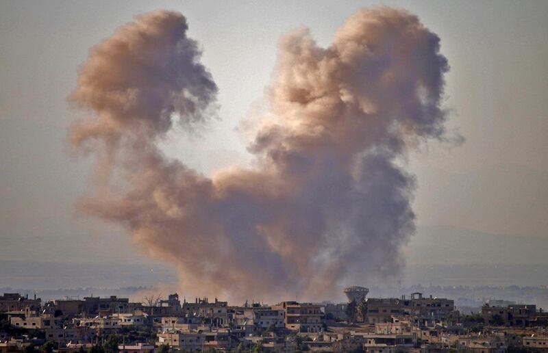 TOPSHOT - Smoke rises above opposition held areas of the Daraa province countryside during airstrikes by Syrian regime forces on June 27, 2018. Russian-backed regime forces have for weeks been preparing an offensive to retake Syria's south, a strategic zone that borders both Jordan and the Israeli-occupied Golan Heights. / AFP / Mohamad ABAZEED
