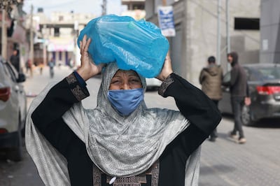 A Palestinian woman carries bottles of water on her head, in Rafah in the southern Gaza Strip. AFP