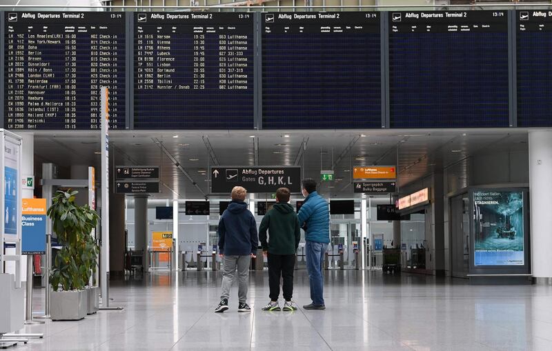 Passengers stand in front of a display board in a terminal of the Franz-Josef-Strauss airport in Munich, southern Germany. AFP
