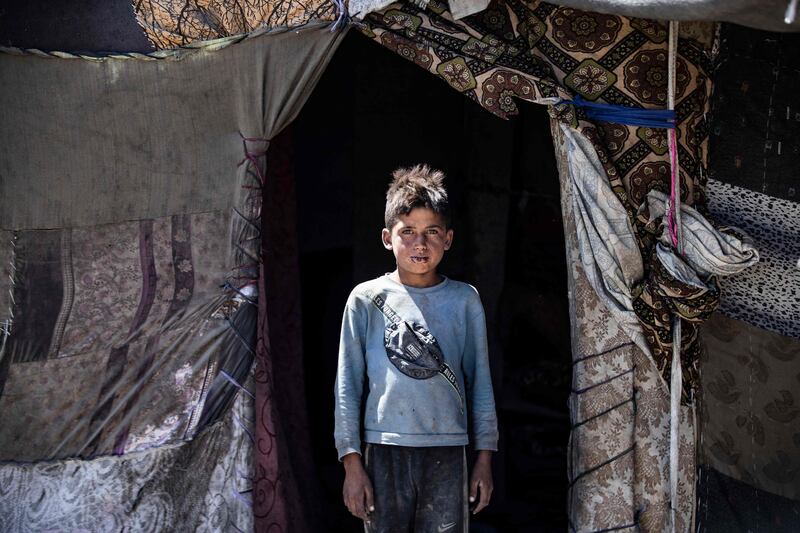 A boy shelters in his tent at the Sahlat al-Banat makeshift camp on the outskirts of the northern Syrian city of Raqa. AFP