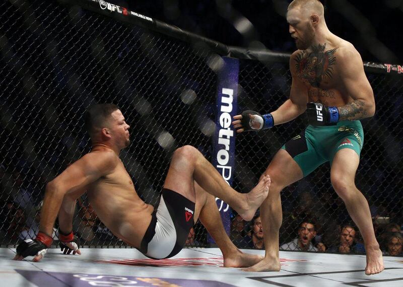 Conor McGregor stands over Nate Diaz during their welterweight match at UFC 202. AP