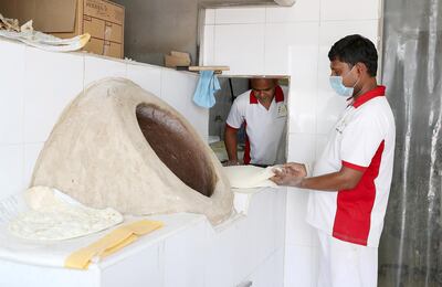 AJMAN , UNITED ARAB EMIRATES , JULY 26 – 2018 :- Mohammed Feroz Khan ( center ) and Mohammed Shamshed ( right ) making bread at the Dar Al Muwaihat Bakery & Restaurant on Sheikh Ammar street in Al Muwaihat area in Ajman.  ( Pawan Singh / The National )  For News. Story by Salam Al Amir