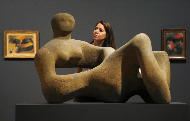 A gallery staff member poses behind Recumbent Figure by Henry Moore before the press view of the Kenneth Clark: Looking for Civilisation exhibition at Tate Britain in London on May 19, 2014. The exhibition looks at Clark’s role as patron, collector, art historian, public servant and broadcaster, and how he helped shape the course of British art. Suzanne Plunkett / Reuters