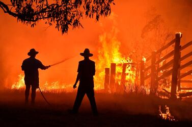 This file photo taken on November 12, 2019 shows residents defending a property from a bushfire at Hillsville near Taree, 350km north of Sydney. Australia's unprecedented 2019-2020 bushfires were "clearly" fuelled by climate change, according to the findings of a government inquiry released on August 25, 2020. AFP