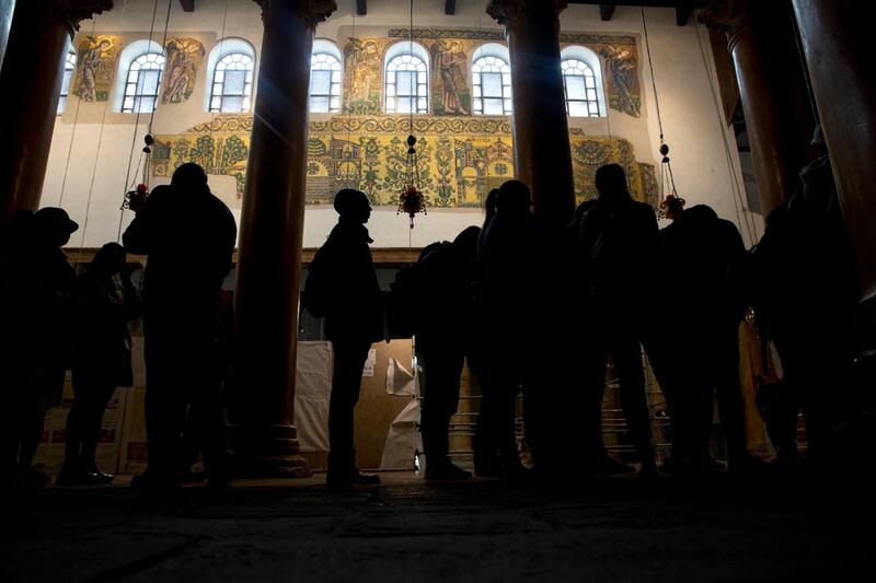 Visitors stand bellow a restored part of a fresco inside the Church of the Nativity in Bethlehem. AP Photo
