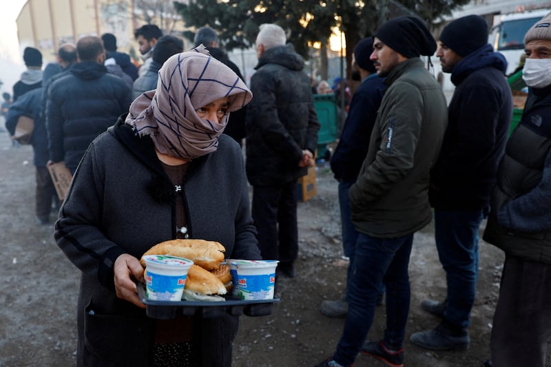 A displaced woman receives food inside a stadium in Kahramanmaras, Turkey. Reuters