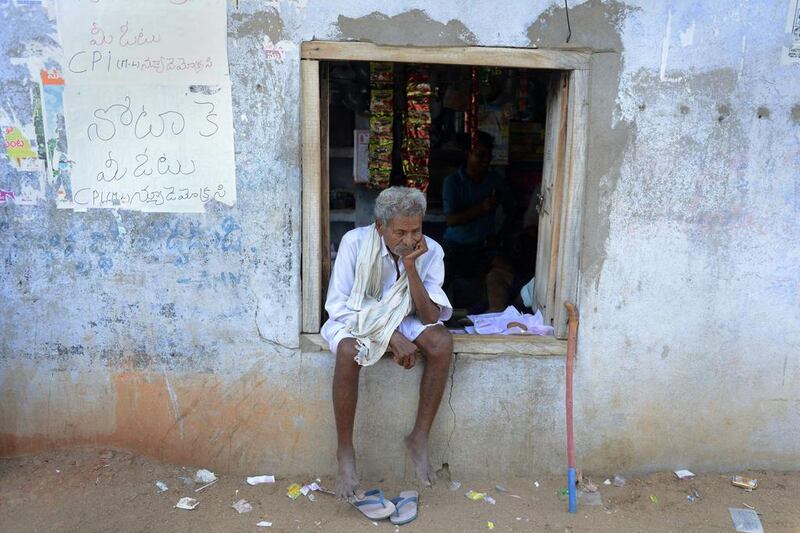 An Indian voter sits alongside a poster saying vote for None Of The Above (NOTA) placed on a wall near a polling station in Bollavaram village in Kurnool district, some 250 kilometers from Hyderabad. Noah Seelam / AFP