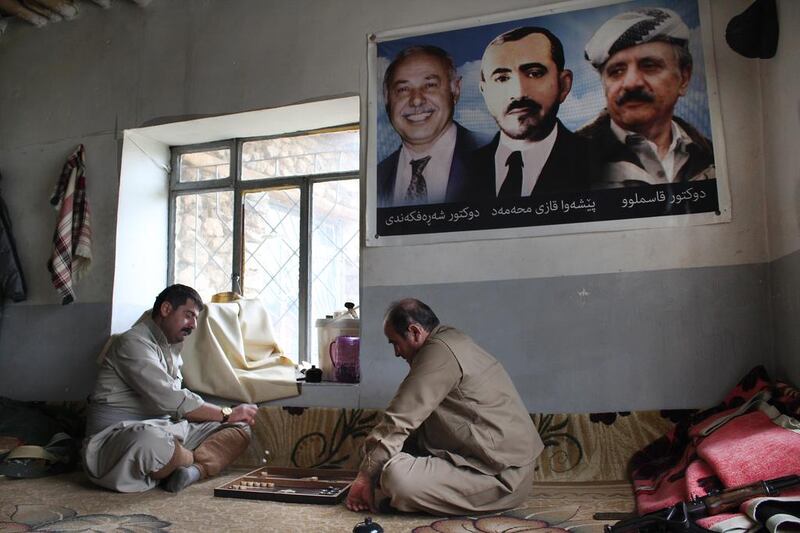 Kheder Pakdaman, right, one of the KDPI's senior Peshmerga commanders, relaxes with a game of Backgammon while party luminaries watch on. (Florian Neuhof for The National)