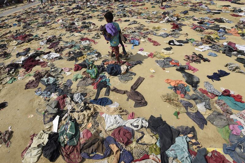 A Rohingya Muslim boy walks past discarded clothing on the ground at the Bhalukali refugee camp near Ukhia on September 16, 2017.
According to the UN nearly 400,000 Rohingya have arrived in Bangladesh since August 25 after fleeing a military crackdown launched by Myanmar's military in response to attacks by Rohingya rebels.
 / AFP PHOTO / DOMINIQUE FAGET