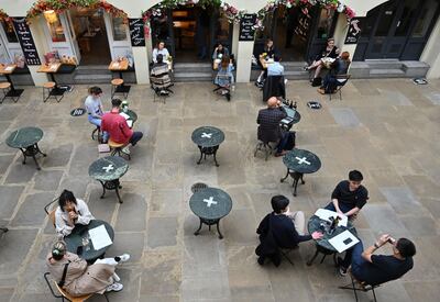 Customers sit at socially distanced tables in Covent Garden in London on July 4, 2020, as restrictions are further eased during the novel coronavirus COVID-19 pandemic. Restaurants and bars reopened Saturday as part of a wider government plan to relaunch the hospitality, tourism and culture sectors and help the UK economy recover from more than three tough months of lockdown. / AFP / JUSTIN TALLIS
