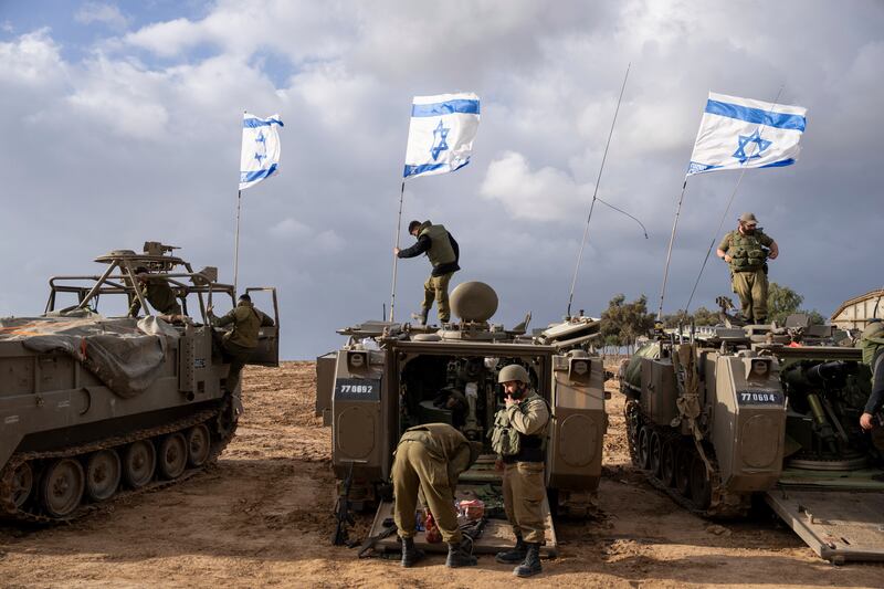 Israeli soldiers work on armoured military vehicles along the border with the Gaza Strip. AP