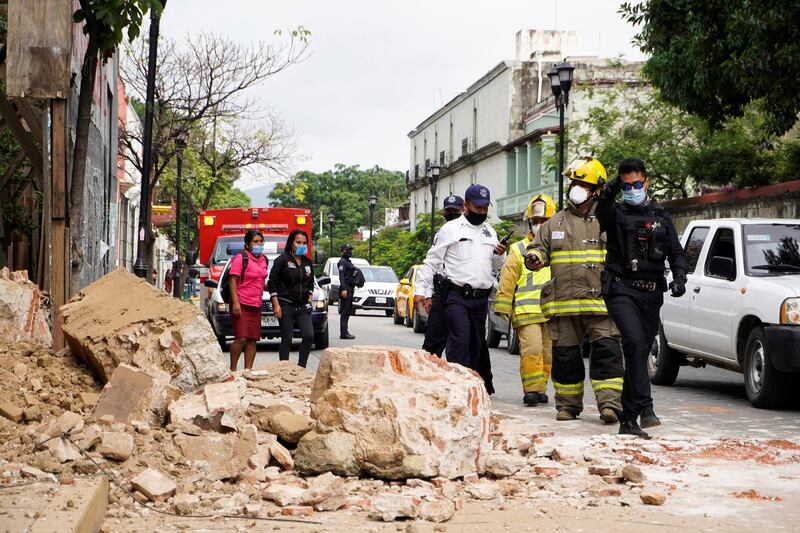 Members of the police and fire department observe the damage caused by a collapsed fence wall in Oaxaca, Mexico.  EPA