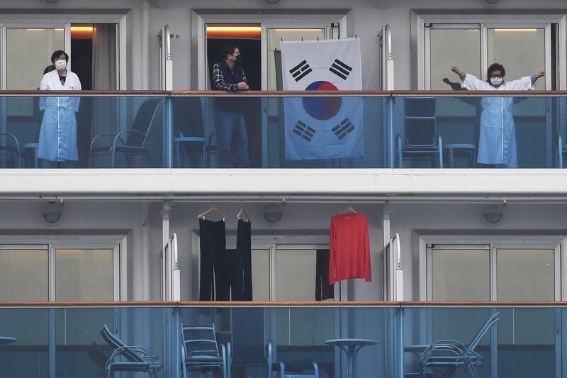 Passengers look out from their balconies on the Diamond Princess cruise ship. AFP