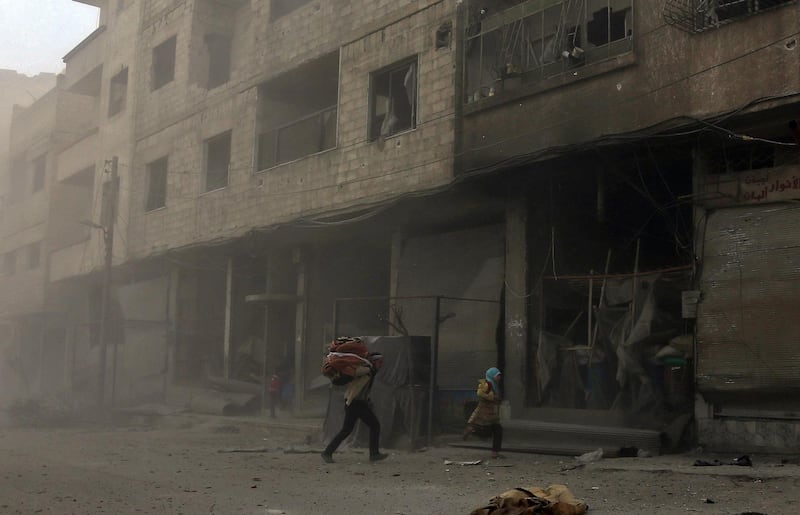 Syrians run from cover in Hamouria during Syrian government shelling on rebel-held areas in the Eastern Ghouta region on the outskirts of the capital Damascus on March 6, 2018. Abdulmonam Eassa / AFP