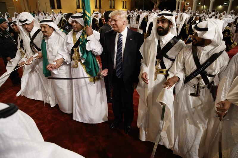 Donald Trump holds a sword and sways with traditional dancers during a welcome ceremony in Riyadh. Evan Vucci / AP Photo