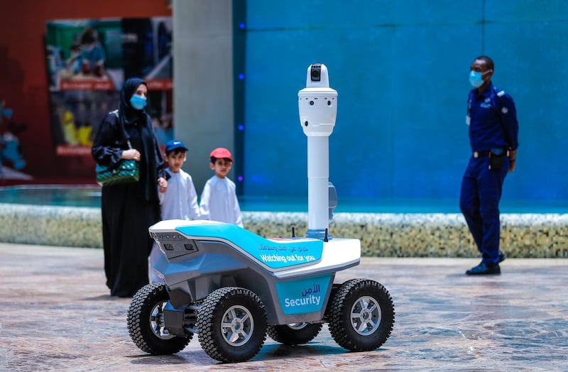 Abu Dhabi, United Arab Emirates, August 19, 2020.  
   Children are amazed at a roving robot on wheels which does thermal checks around the Yas Mall.
Victor Besa /The National
Section:  NA
Reporter:  Haneen Dajani