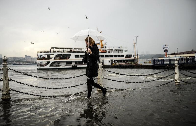 A woman walks through a flooded quay on June 2, 2014, at Uskudar district of Istanbul during a rainy day. AFP PHOTO / BULENT KILIC