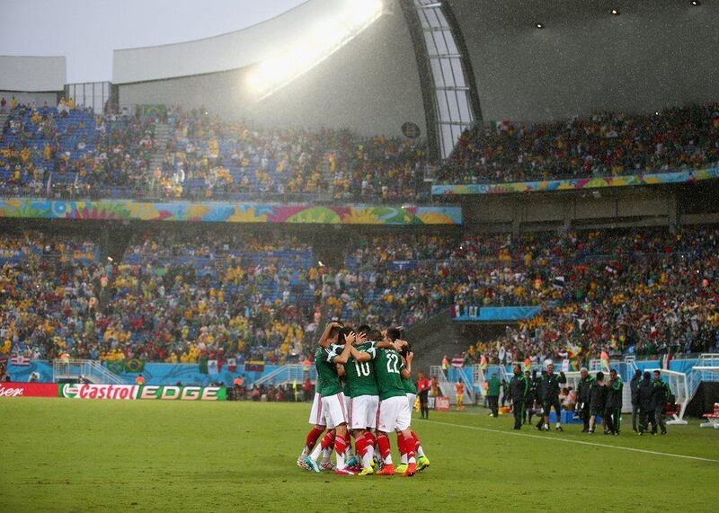 Mexico players celebrate Oribe Peralta's goal in their World Cup Group A victory over Cameroon on Friday in Natal, Brazil. Julian Finney / Getty Images