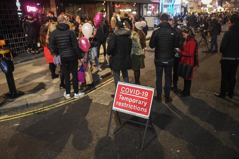People are seen queuing outside a restaurant in Soho. Getty Images