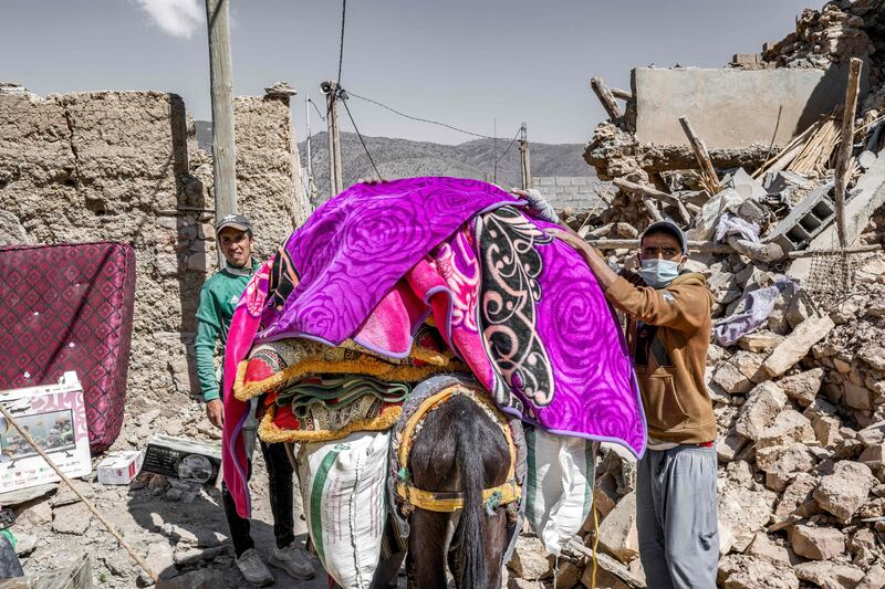 Residents load a donkey with blankets. AFP