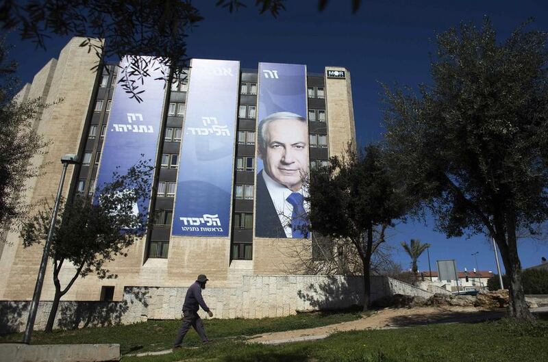 A pedestrian walks past a Likud party campaign banner of Israel's prime minister Benjamin Netanyahu in Jerusalem as Israelis head to the polls on March 17 in a closely contested election. Ronen Zvulun /Reuters