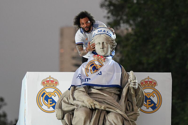 Marcelo puts up a flag on top of a statue on the Plaza Cibeles square in Madrid during Real Madrid's La Liga title celebrations. AFP