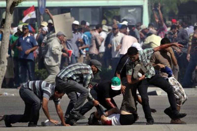 Supporters of Mohammed Morsi carry a man shot near the Republican Guard building in Cairo on Friday. AP Photo