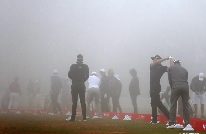 Players practice at the driving range during the fog delay of the second round of the Abu Dhabi HSBC Golf Championship on Friday. Karim Sahib / AFP