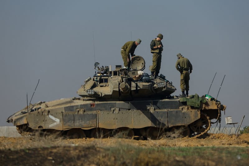 Israeli soldiers work on a tank near the border with Gaza. Reuters