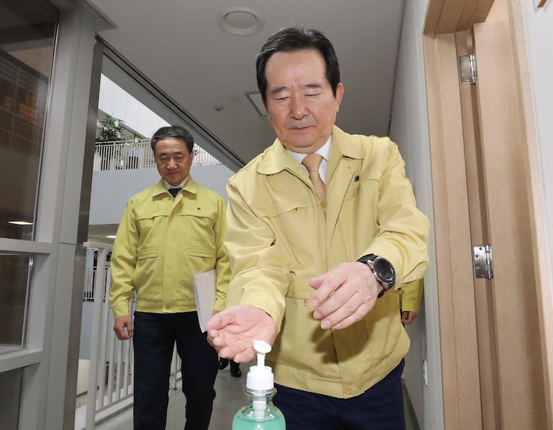 South Korean Prime Minister Chung Sye-kyun (R) sanitizes his hands before attending a meeting to discuss measures to prevent the spread of the novel coronavirus. EPA