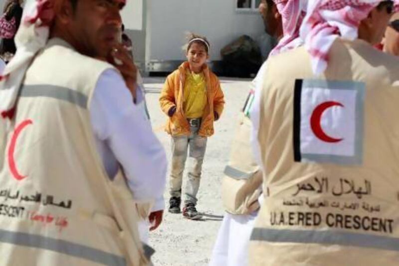 UAE Red Crescent members receive refugees as they arrive at the new Mrajeeb Al Fhood camp 37km from the border with Syria. Reuters