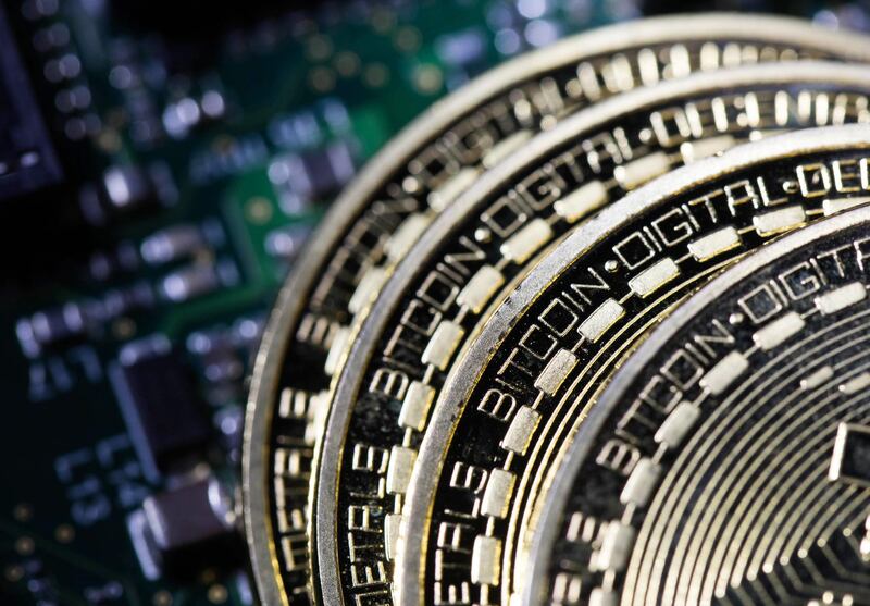 Three coins representing Bitcoin cryptocurrency  sit on a computer circuit board in this arranged photograph in London, U.K., on Tuesday, Feb. 6, 2018. Cryptocurrencies tracked by Coinmarketcap.com have lost more than $500 billion of market value since early January as governments clamped down, credit-card issuers halted purchases and investors grew increasingly concerned that last year’s meteoric rise in digital assets was unjustified. Photographer: Chris Ratcliffe/Bloomberg