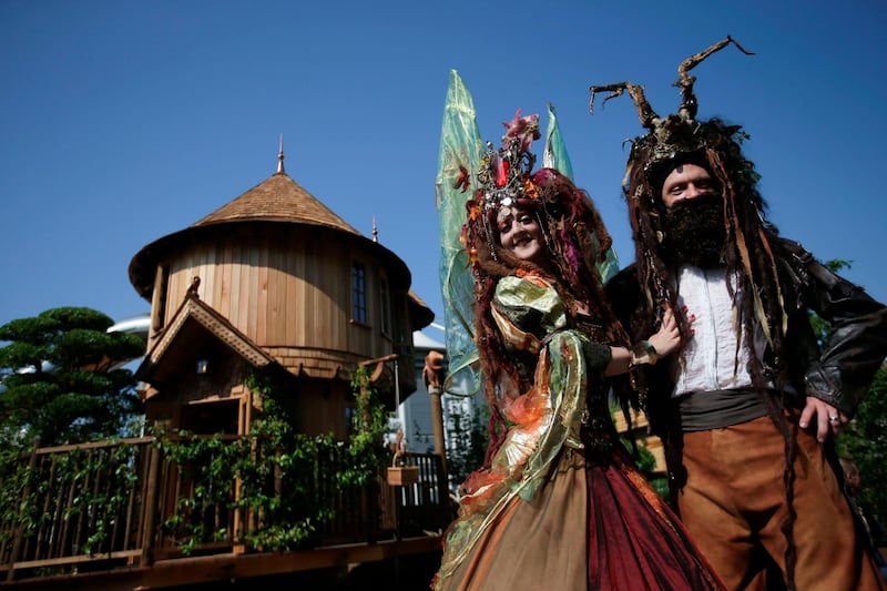 Performers pose in front of the Blue Forest Tree Houses.