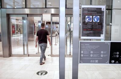 Abu Dhabi, United Arab Emirates, April 21, 2020. 
  Early Ramadan shoppers at Carrefour Yas Mall.  A gloves and mask sign posted at the entrance of the mall.
Victor Besa / The National
Section:  NA
For:  Stock images