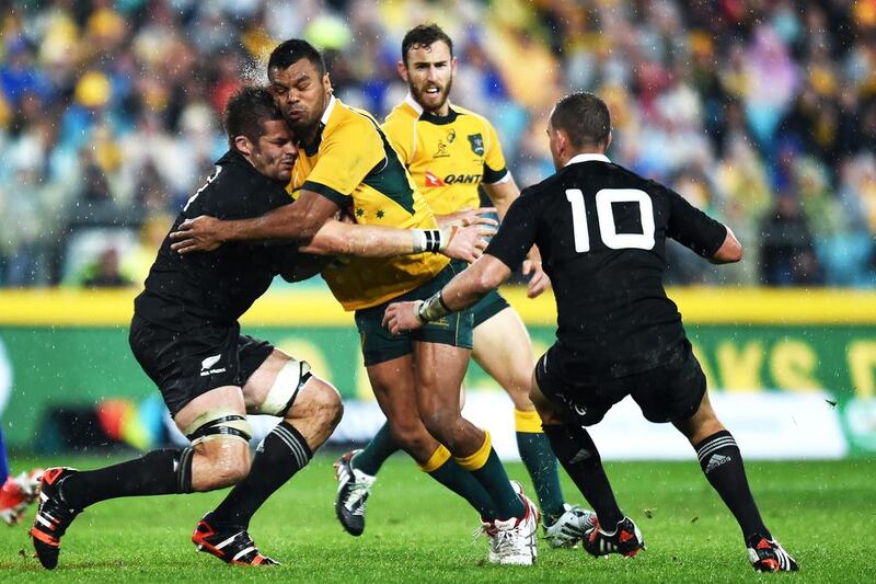 Richie McCaw of New Zealand, left, tries to hold back Australia’s Kurtley Beale, right, during the opening game of the Bledisloe Cup series at the ANZ Stadium in Sydney. Paul Miller / EPA