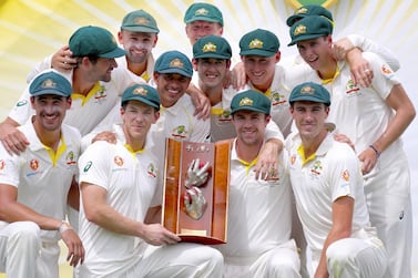 Australia captain Tim Paine, front left centre, holds the trophy as he poses with teammates after beating Sri Lanka 2-0 in the recent Test series. EPA