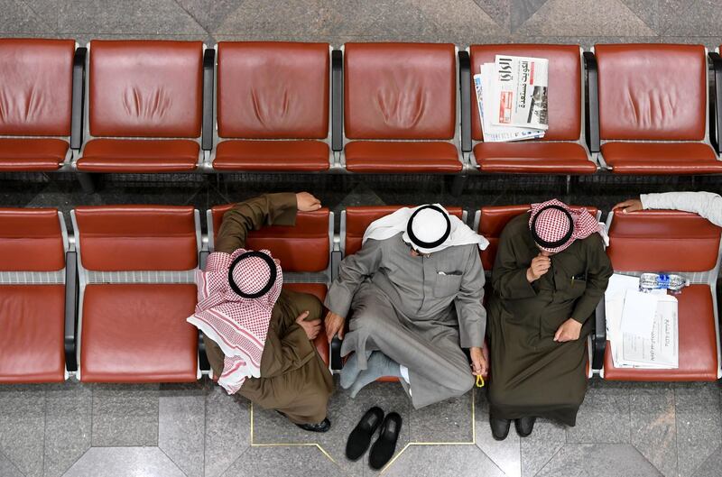 Kuwaiti traders sit and observe the stock market's developments at the trading hall of the Kuwait Stock Exchange, in Kuwait City.  EPA