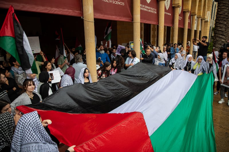 Students at the American University of Beirut unfurl a large Palestinian flag.