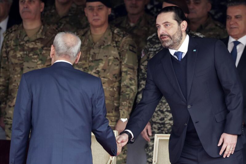 Resigned Prime Minister Saad Hariri, right, shakes hands with Mr.  Berri. AP Photo