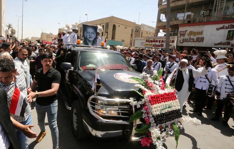 Mourners accompany the hearse transporting the casket through the streets of Baghdad. AFP
