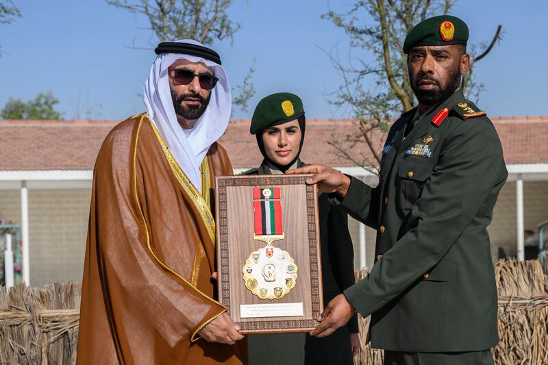 Mohamed Ahmad Al Bowardi, UAE Minister of State for Defence Affairs, left, presents a medal to a member of the UAE Armed Forces at the unification ceremony at Abu Mreikhah