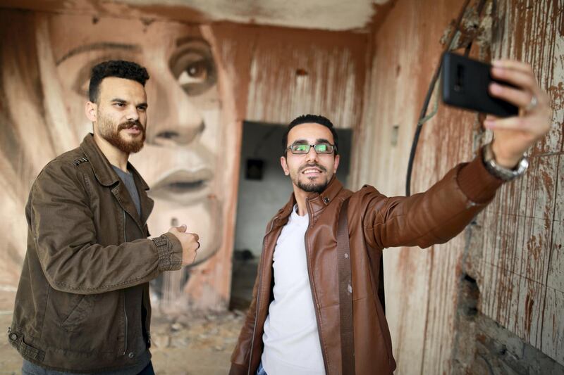 al-Jabali poses in front of his art works. Courtesy Fady Hanona