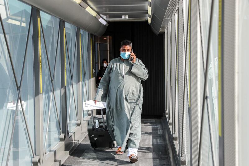 A passenger walks towards the plane ahead of the first flight bound for Cairo after the resumption of flights between Qatar and Egypt, at Doha's Hamad International Airport on January 18, 2021. Egypt reopened its airspace to Qatari flights on January 18 following a thaw in relations between Doha and a Saudi-led bloc. Egypt in June 2017 joined Saudi Arabia, the United Arab Emirates and Bahrain in cutting ties with Qatar, accusing it of being too close to Iran and backing the Muslim Brotherhood, seen by Cairo and its Gulf allies as a "terrorist" group. Qatar has denied the charges. / AFP / KARIM JAAFAR
