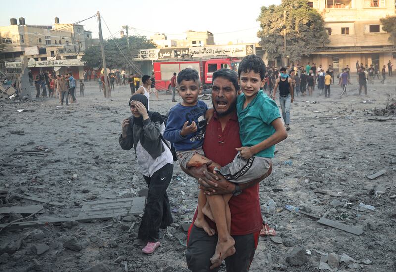 Palestinians cry as they walk away after an area hit by Israeli missiles in Rafah, the Gaza Strip. AP