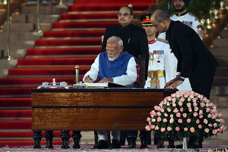 Prime Minister Narendra Modi signs the oath of office at the Rashtrapati Bhavan in New Delhi on June 9. Bloomberg