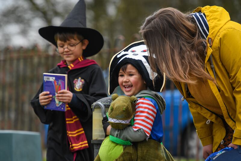 Children dressed up for World Book Day are welcomed to school by their teacher. Getty