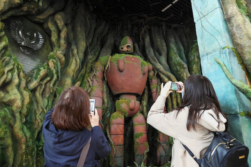 Visitors take pictures of the robot soldiers of 'Tenku no Niwa' at Ghibli's Great Warehouse. AFP