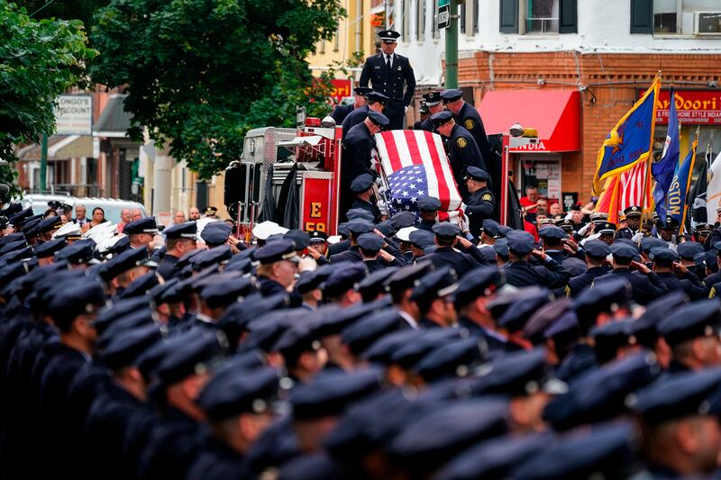 The remains of Lt Sean Williamson, 27, a Philadelphia Fire Department veteran, are brought to a church for his funeral service in the city. Williamson, 51, was killed when a building collapsed. AP