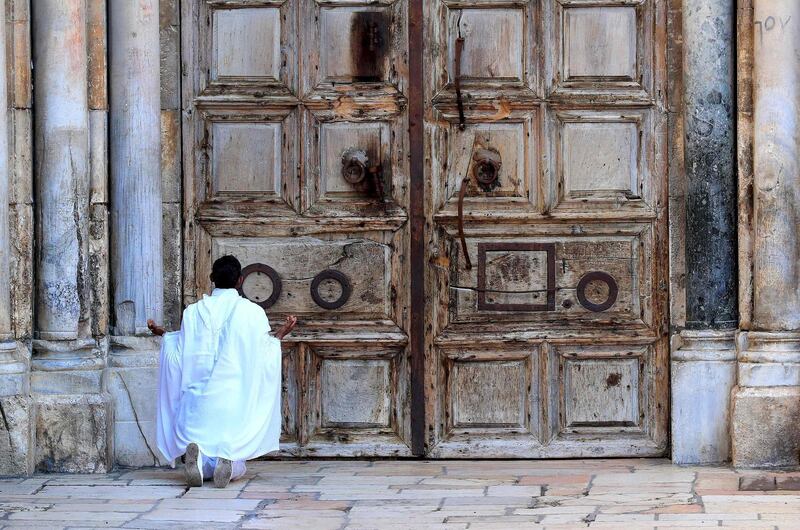 A Christian worshipper prays in front of the closed door of the Church of the Holy Sepulchre before the start of the Easter Sunday service amid the coronavirus disease (COVID-19) outbreak, in Jerusalem's Old City. All cultural sites in the Holy Land are shuttered, regardless of their religious affiliation, as authorities seek to forestall the spread of the deadly respiratory disease. Christians will be prevented from congregating for the Easter service, whether this coming Sunday -- as in the case of Bitar and fellow Catholics -- or a week later on April 19 in the case of the Orthodox.  AFP
